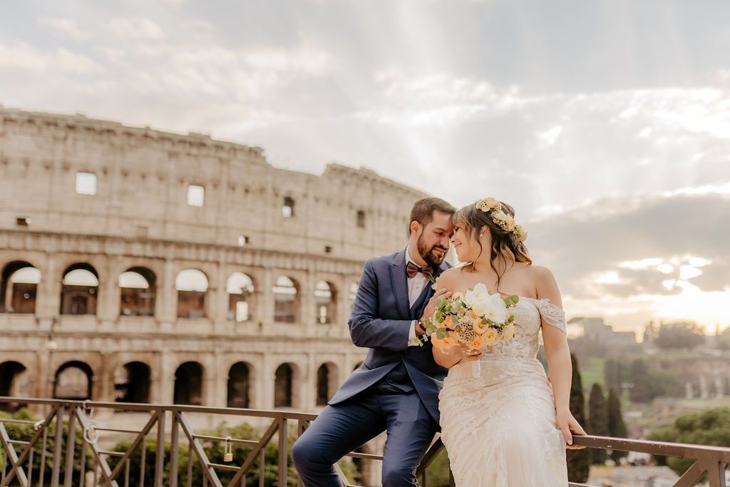 Bride and groom posing in front of the Colosseum in Rome after theur elopement ceremony