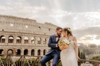 Bride and groom posing in front of the Colosseum in Rome after theur elopement ceremony