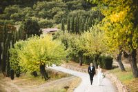 Bride and groom walking down a road in Tuscany