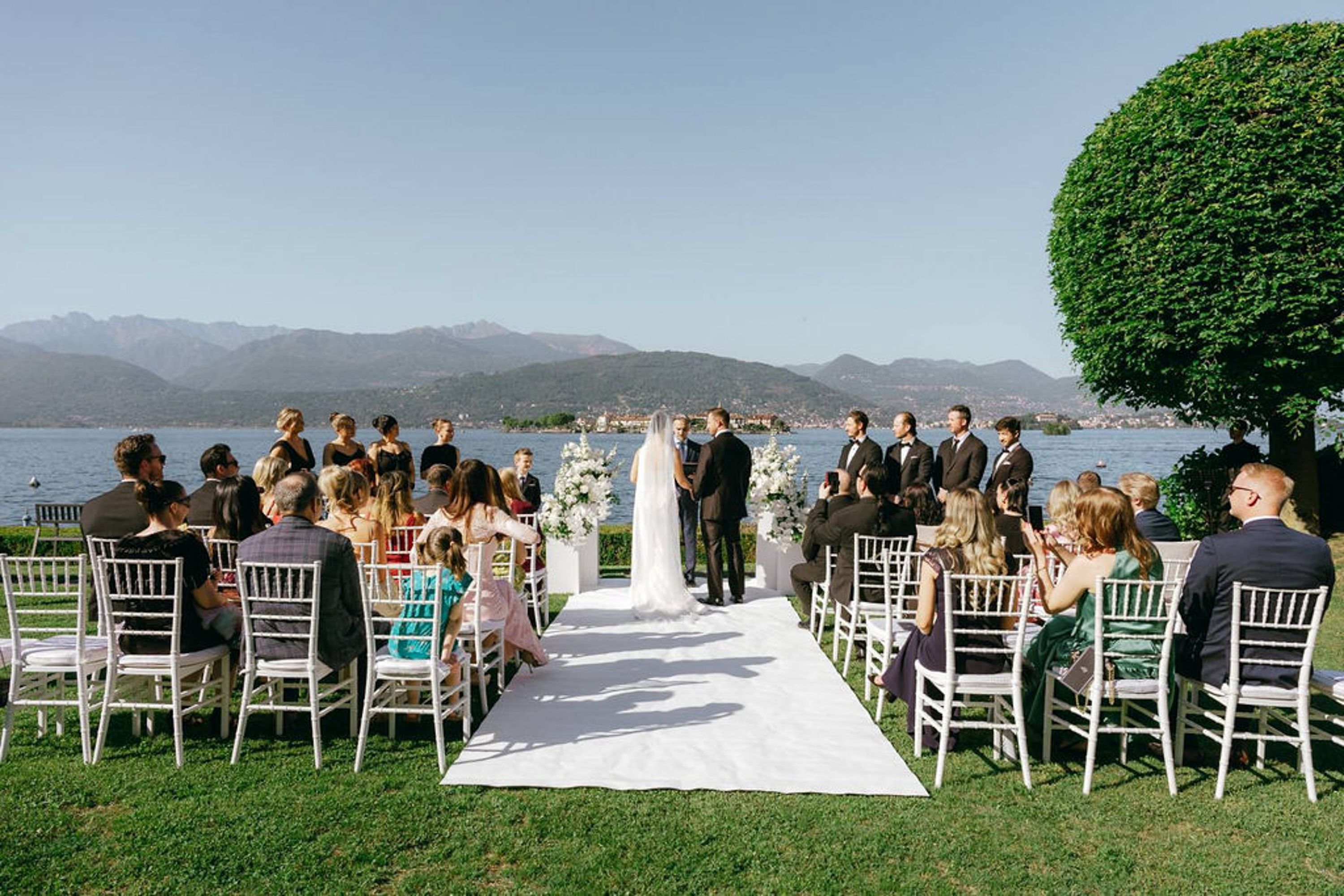 Lakeside ceremony with family and friends gathered for a small wedding in Italy beneath mountain views