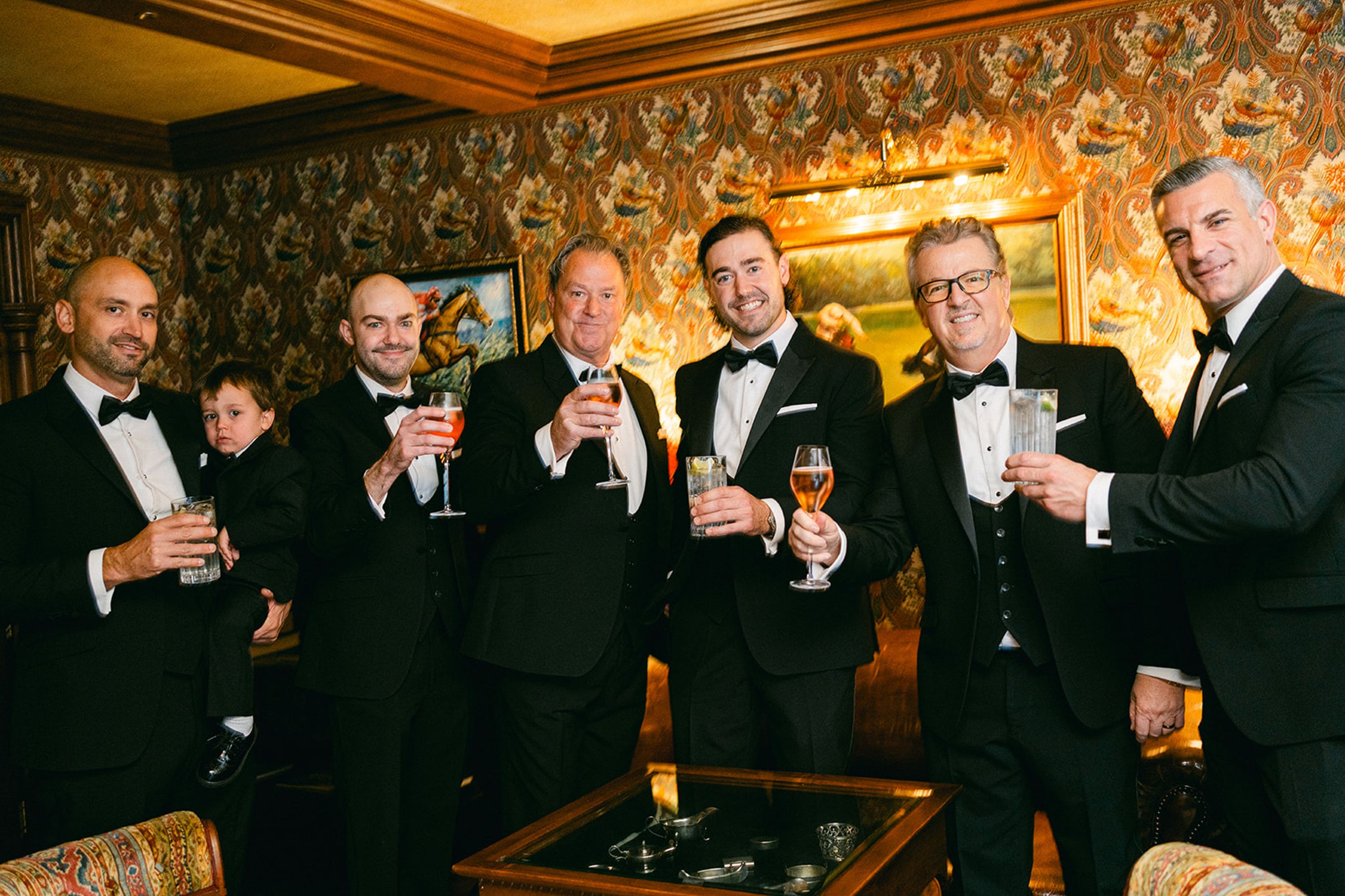 Groom and groomsmen raising a toast before a small wedding in Europe
