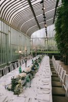 A long white table with a fresh green garland and white flowers in the middle for a small wedding in Ireland