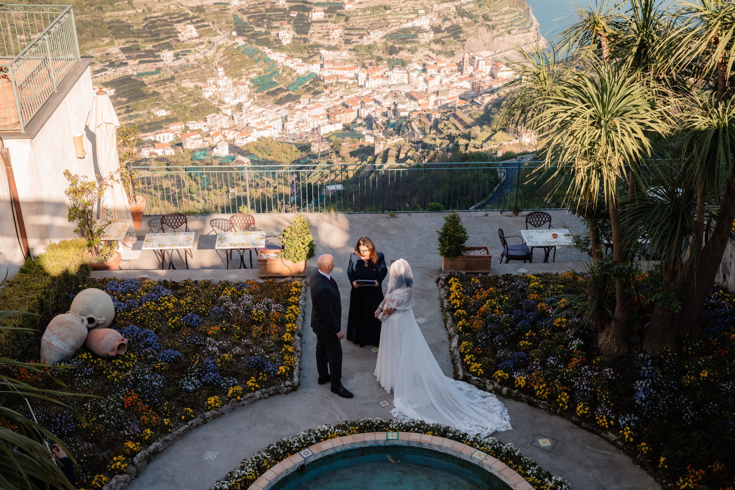 Couple with officiant in a wedding atop a terrace overlooking Ravello and Amalfi Coast in Italy
