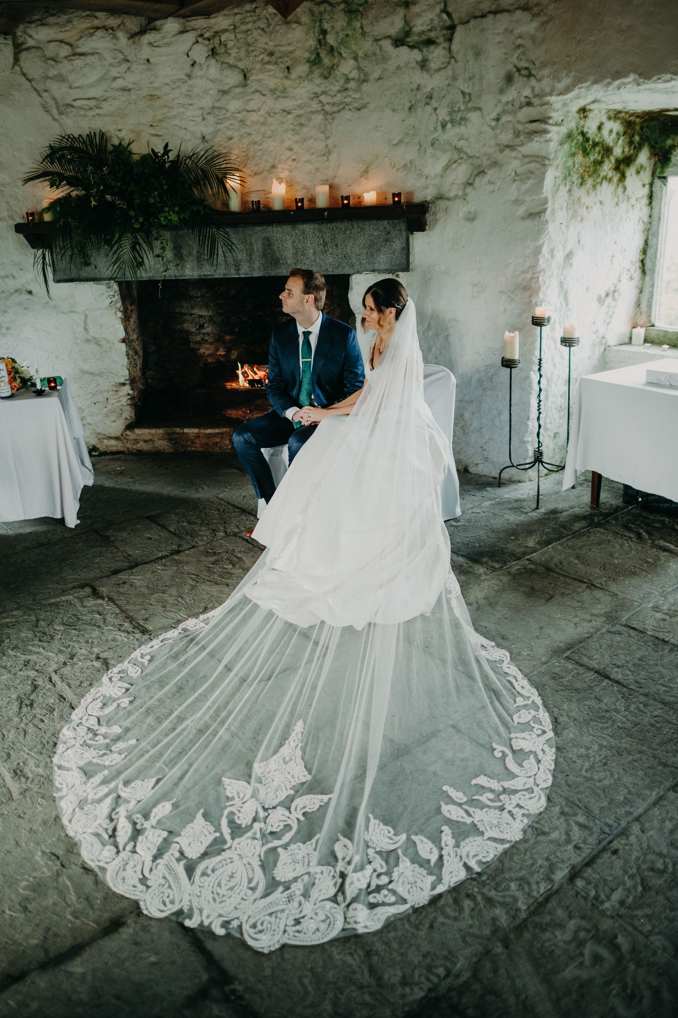 Newlyweds seated by a candlelit fireplace during an intimate wedding in Ireland ceremony.