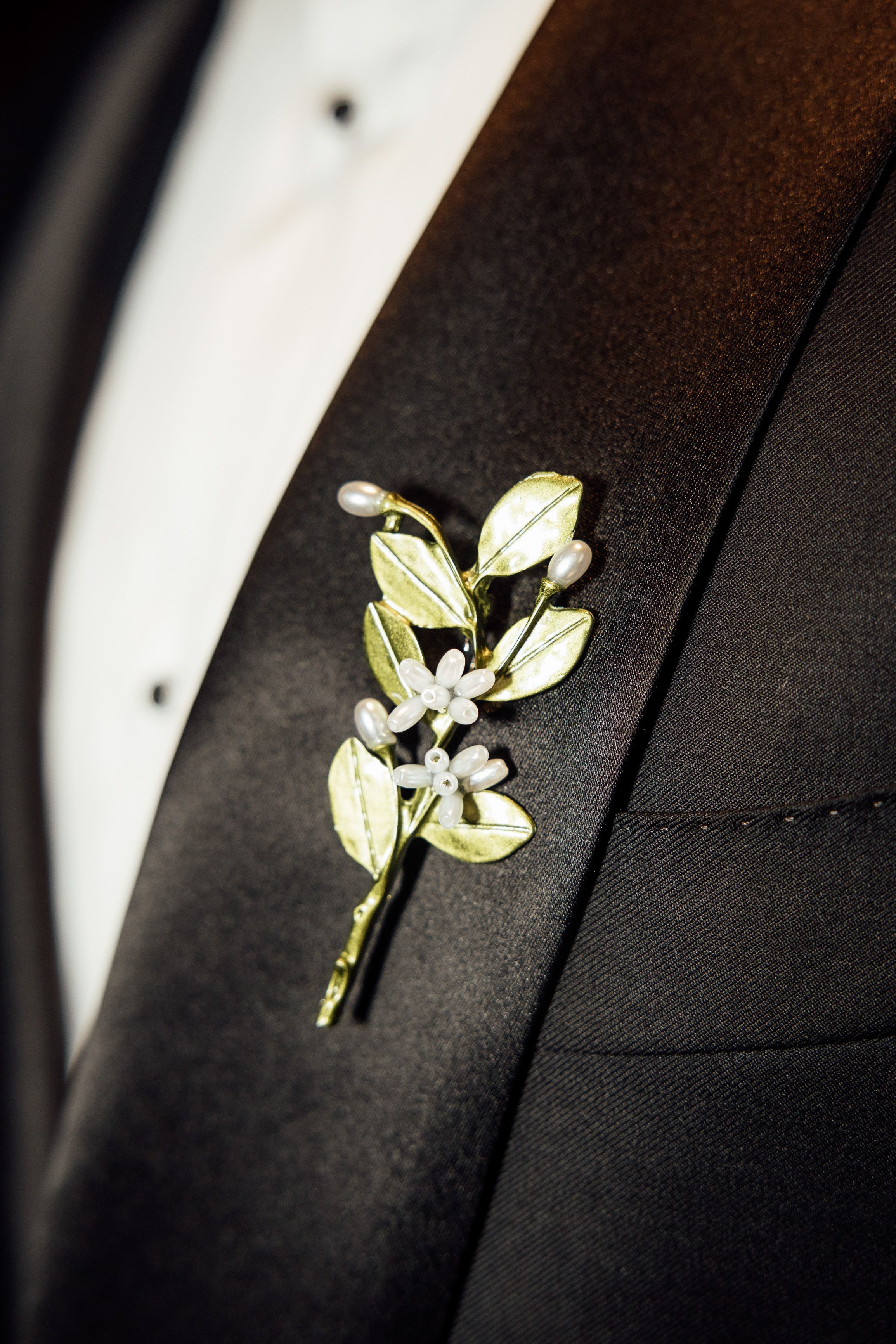 Elegant floral boutonniere pinned to a black tuxedo for an intimate wedding in Austria