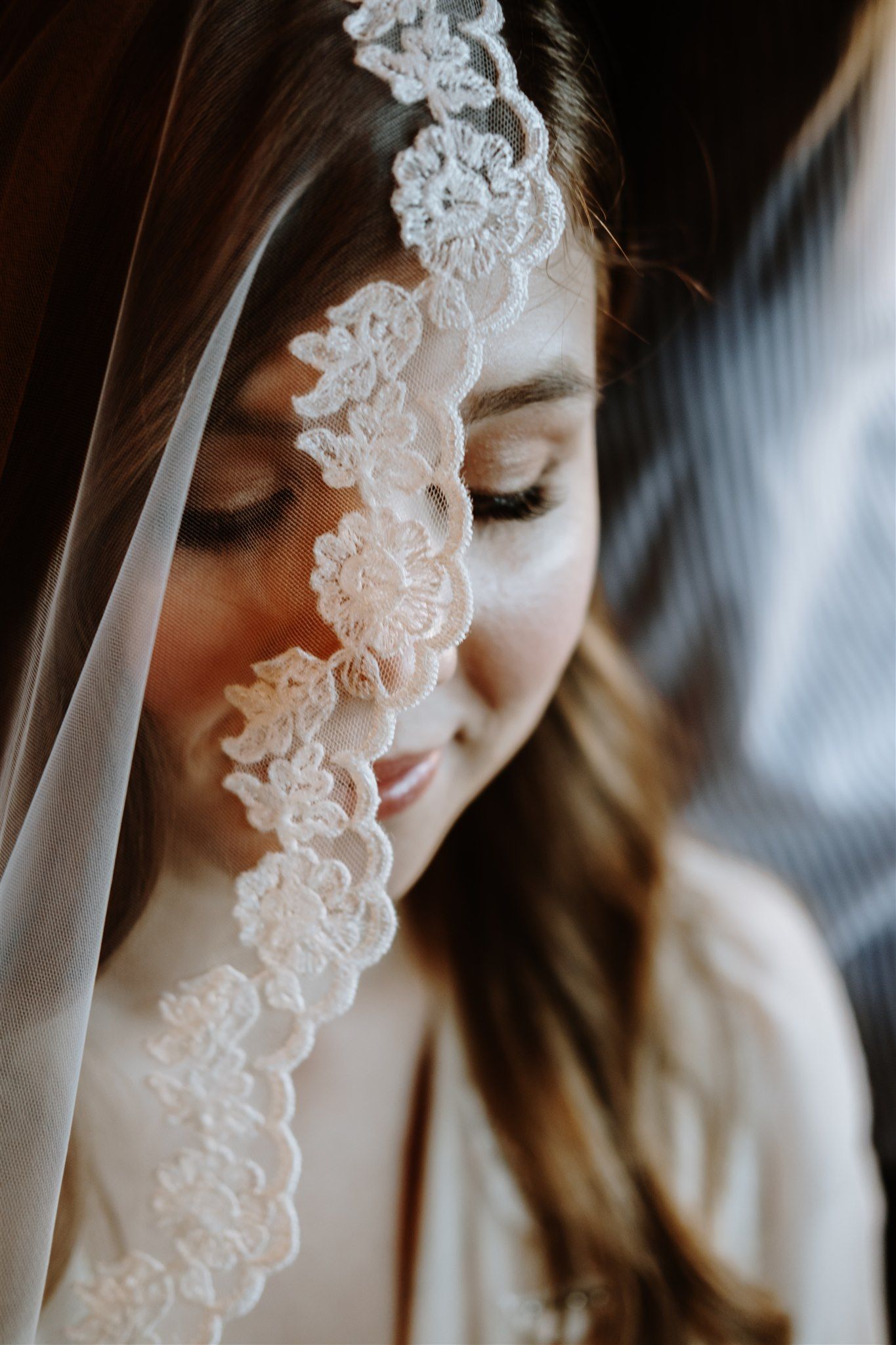 a bride with a lace veil draped across her
