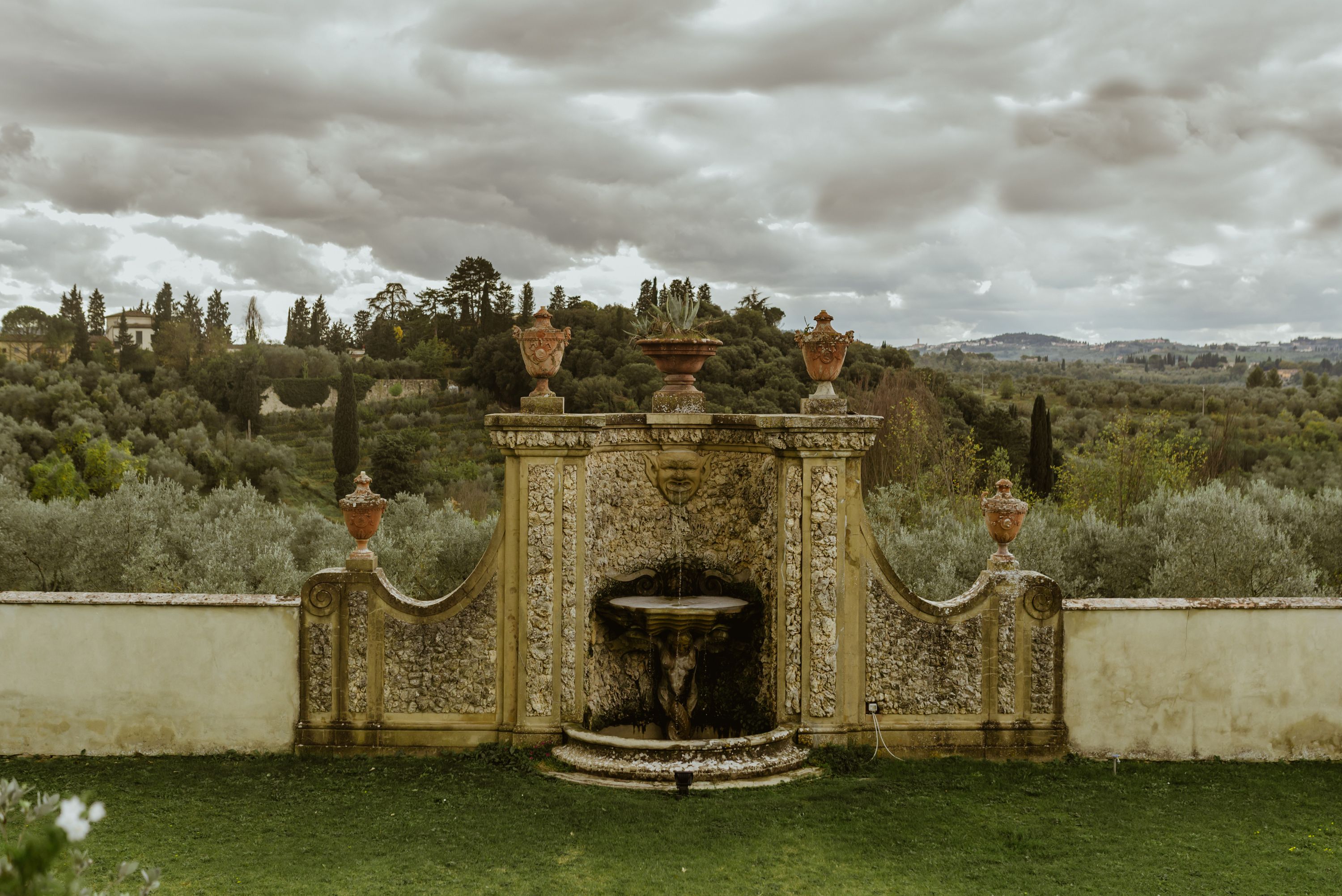 A medieval fountain of a Renaissance hotel and resort in Florence surrounded by the Tuscan greenery