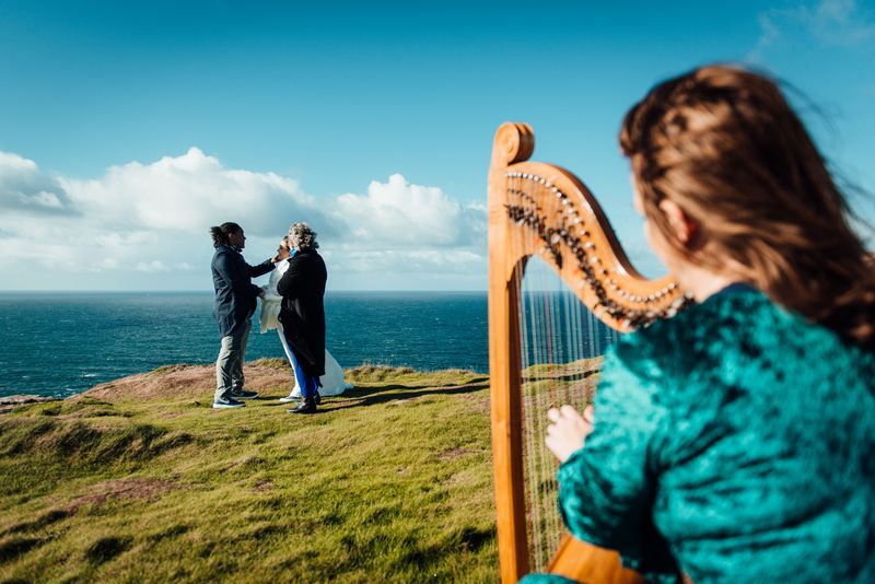 A harp player accompanying a wedding ceremony on the cliffs in Ireland