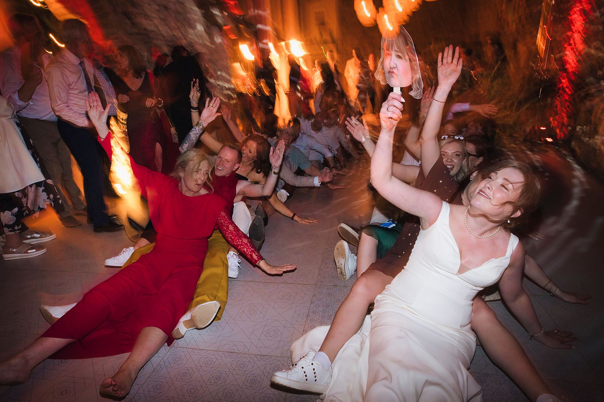 Bride dances with her guests during their wedding party in Spain in a medieval room filled with lights