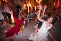 Bride dances with her guests during their wedding party in Spain in a medieval room filled with lights