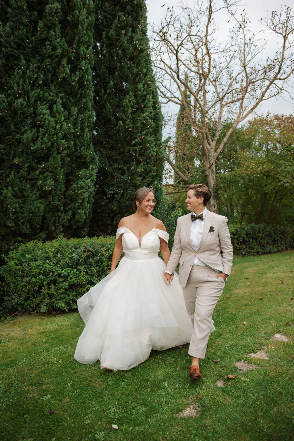 Newlyweds walking along the large Tuscan estate where they had a micro wedding in Italy