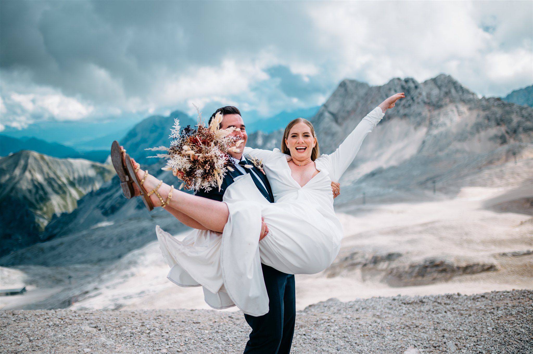 Groom holding bride in his arms an a mountain elopement in Europe