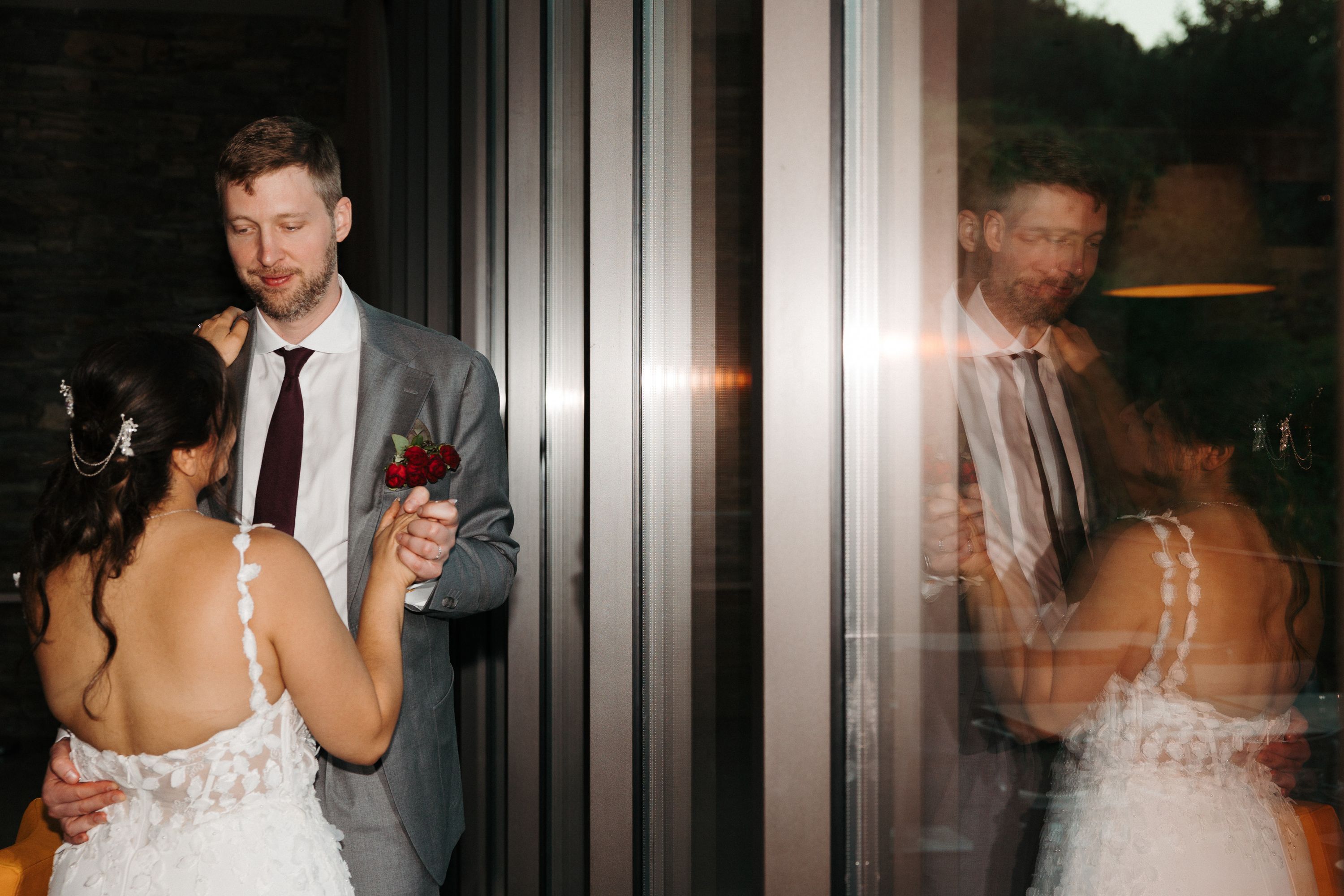 Bride and groom sharing a romantic dance beside reflective glass at a small wedding in Portugal