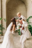 Bride and groom with their little one playing and having fun during the photoshoot of their intimate wedding in Italy