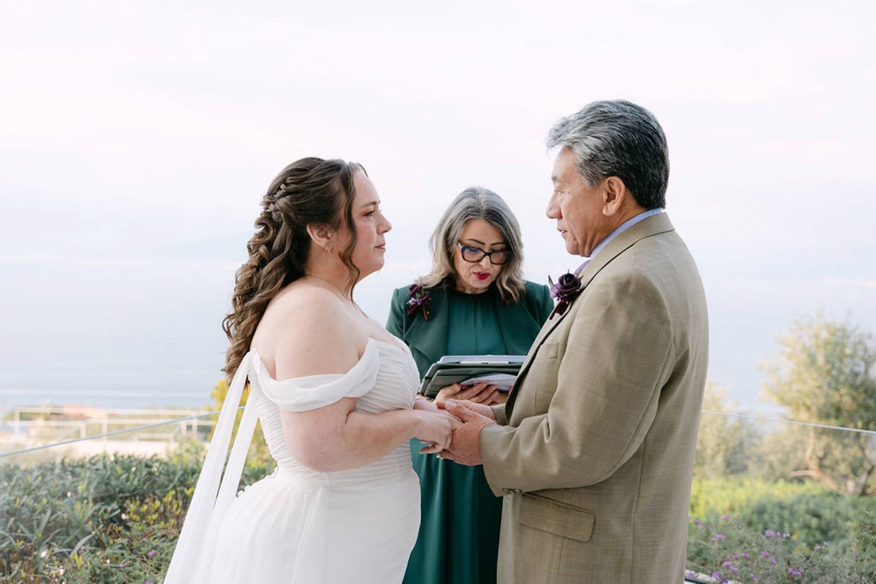Couple exchange vows overlooking the sea at a small wedding in Italy