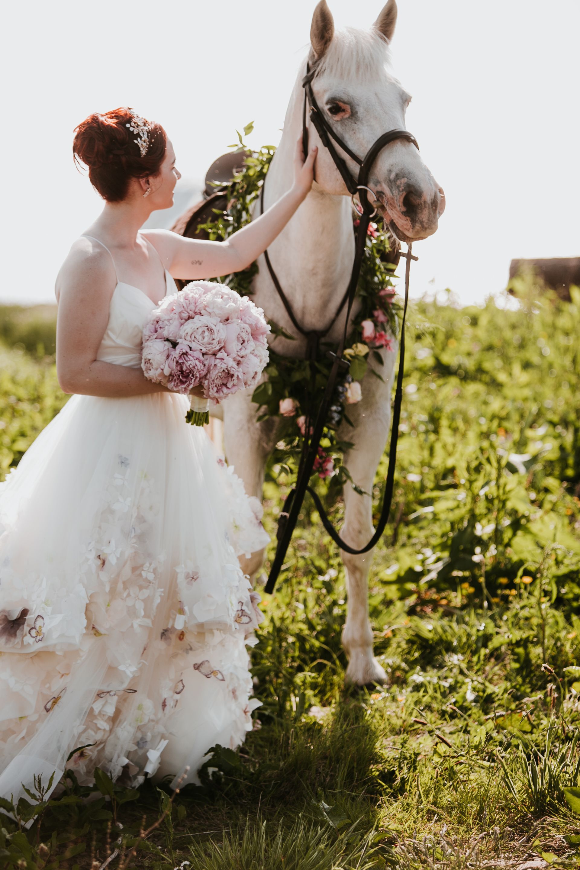 Bride stroking a white horse on her wedding day in Ireland