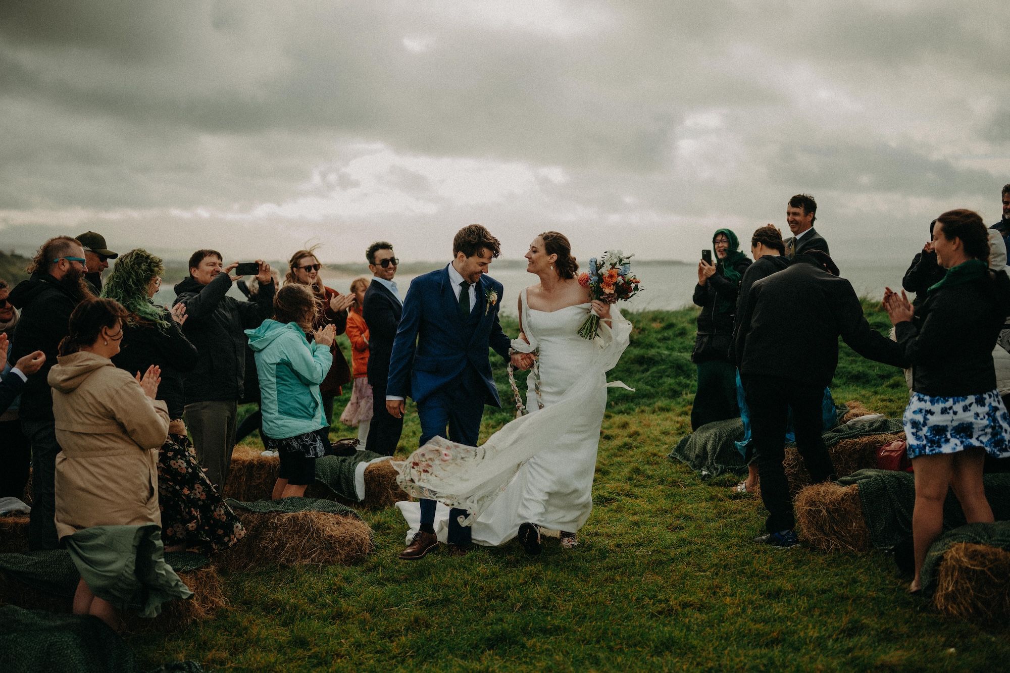 Bride and groom atop the cliffs of Antrim during their micro wedding in Ireland during spring surrounded by their guests