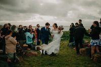 Bride and groom atop the cliffs of Antrim during their micro wedding in Ireland during spring surrounded by their guests