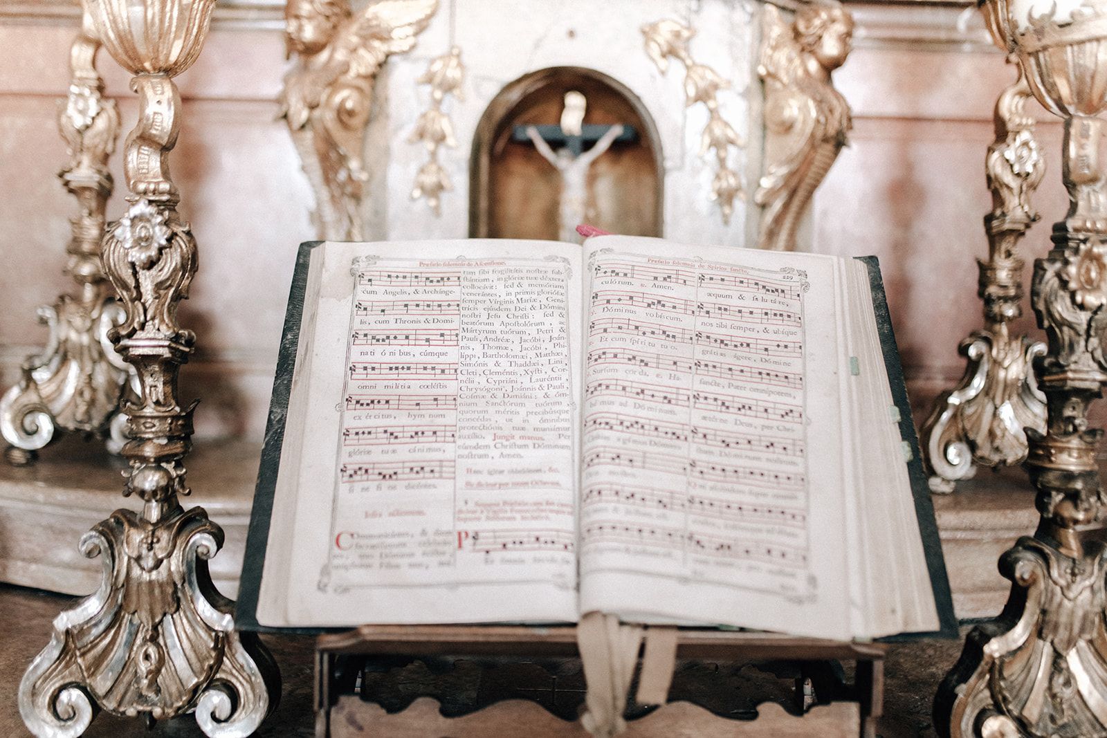 Historic choir book between gilded candlesticks at a baroque chapel altar