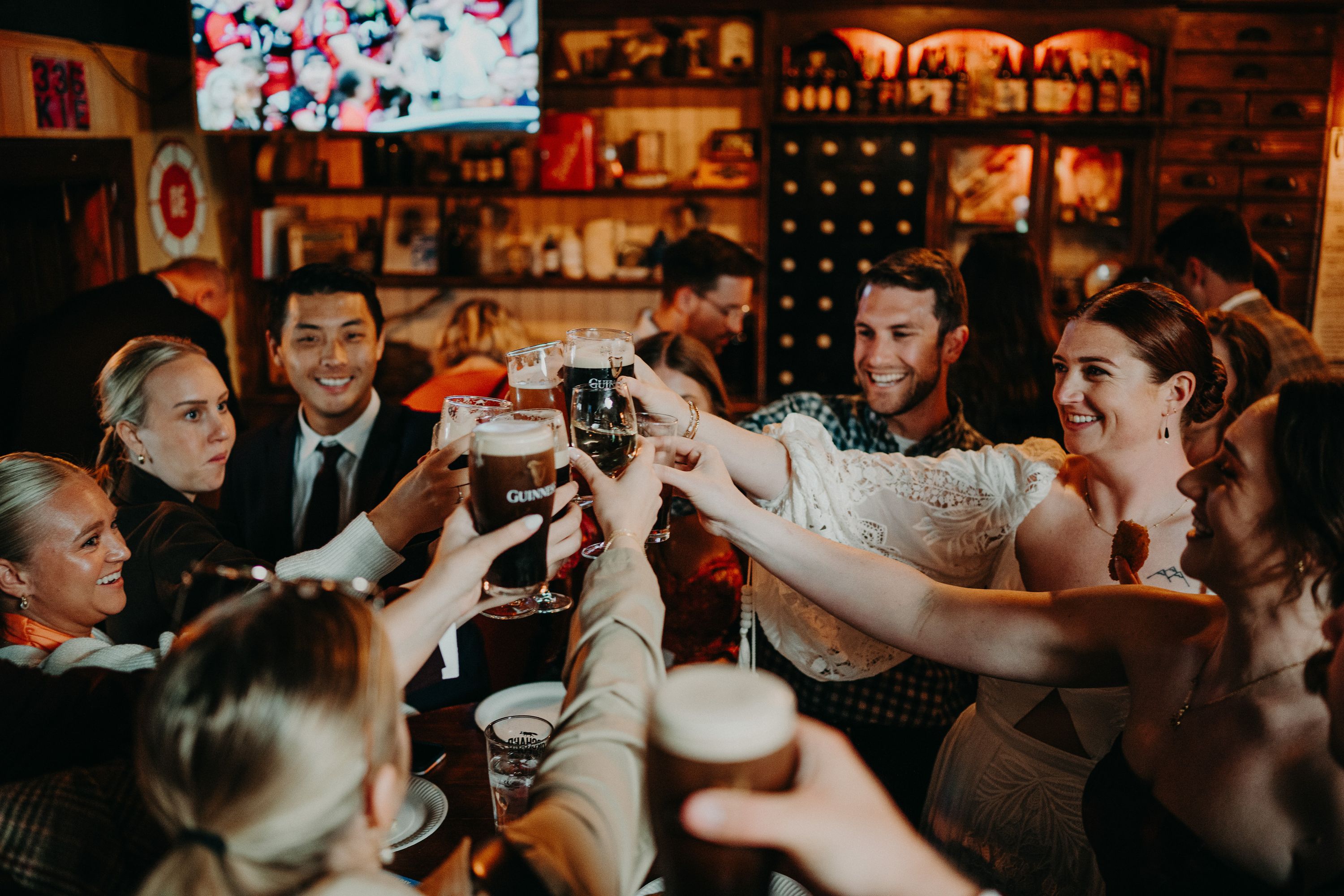 A bride having a toast with her friends and family inside a bar after her small wedding in Ireland