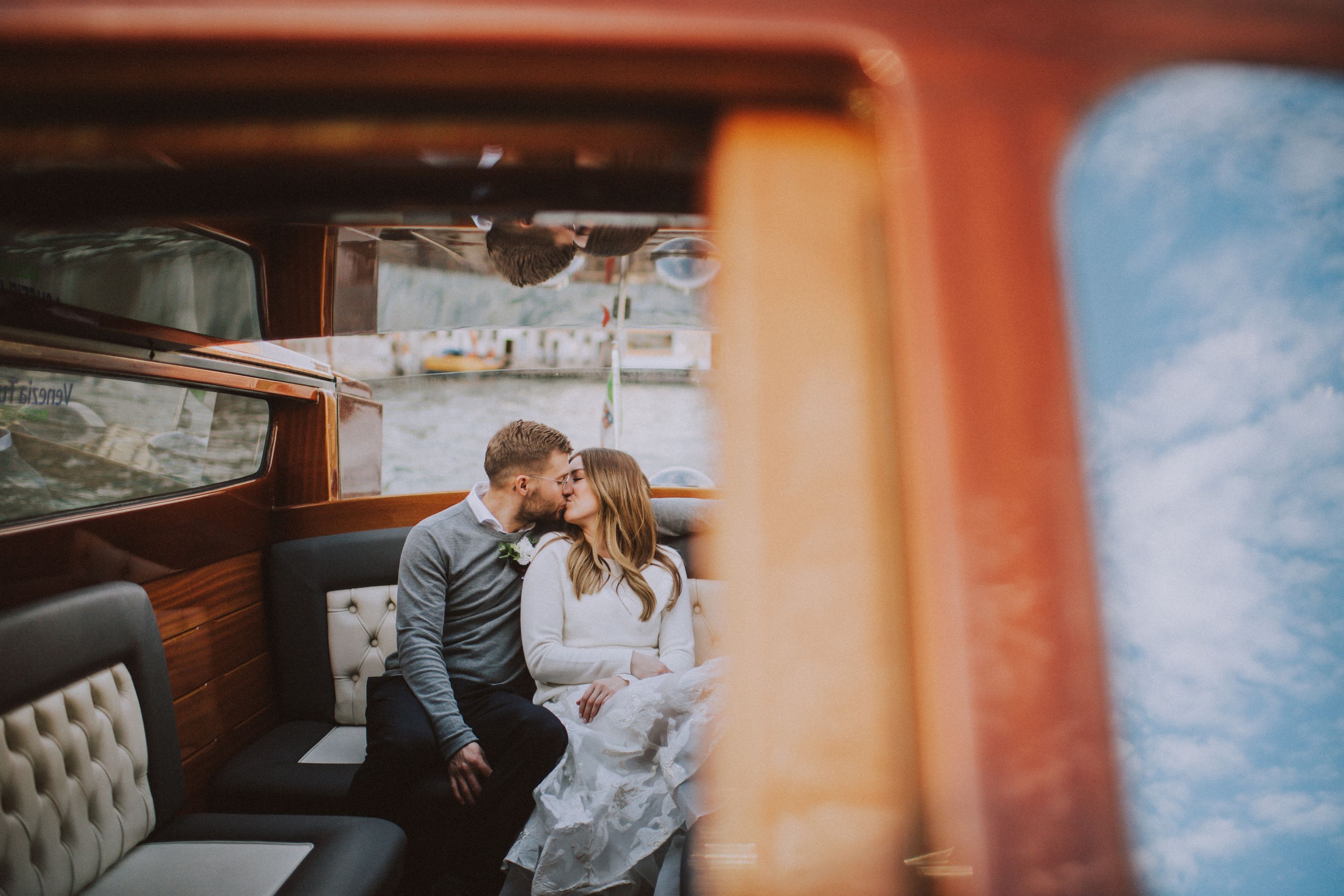 Couple kissing in the cabin of a vintage wooden lake boat