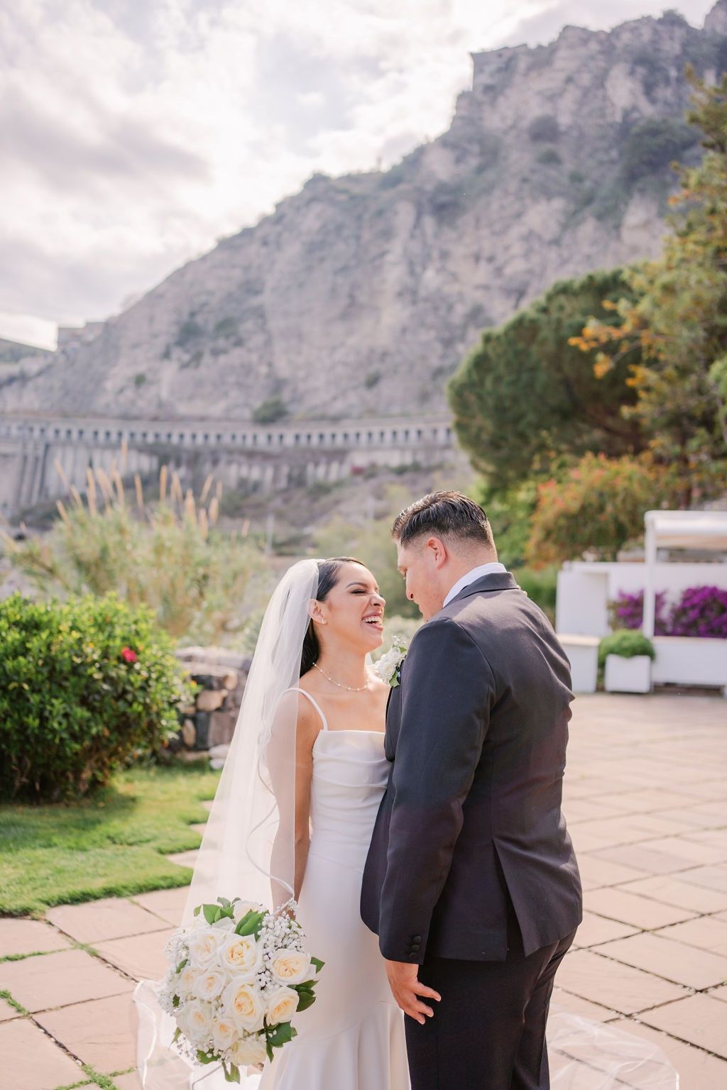 Bride and groom looking at each other during their elopement in Italy with the scenic mountains of Sicily in the background