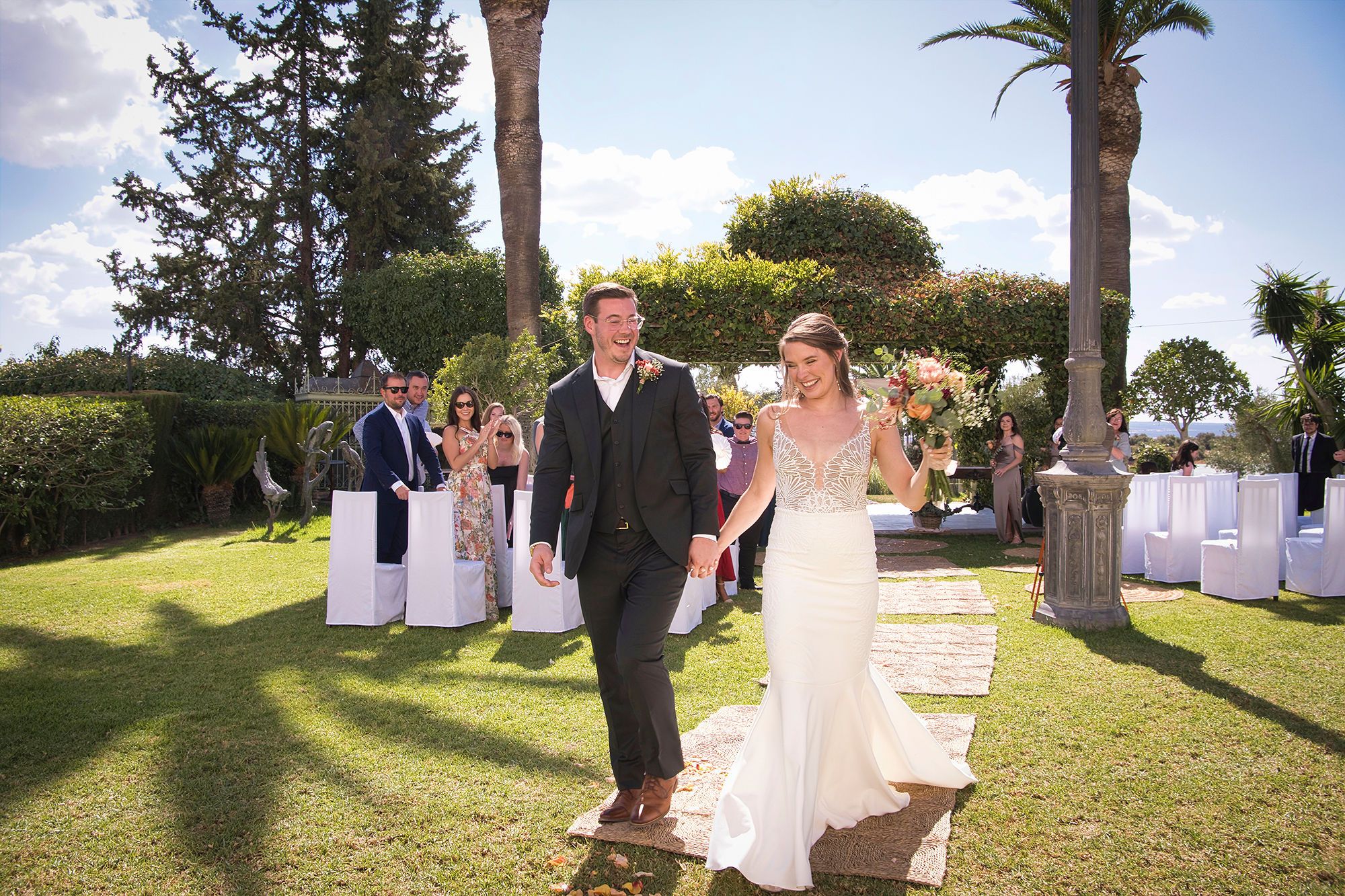 Newlyweds happily walking after the ceremony of their destination wedding in Spain in an Andalusian farmhouse in Cadiz