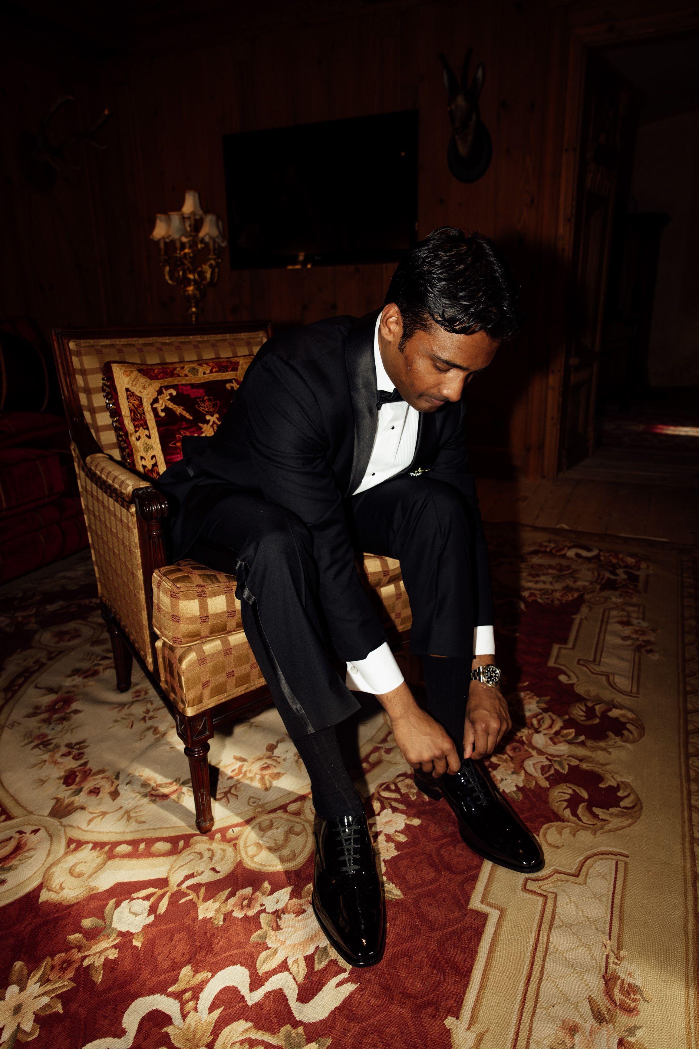 Groom laces his formal shoes before a small wedding in Austria