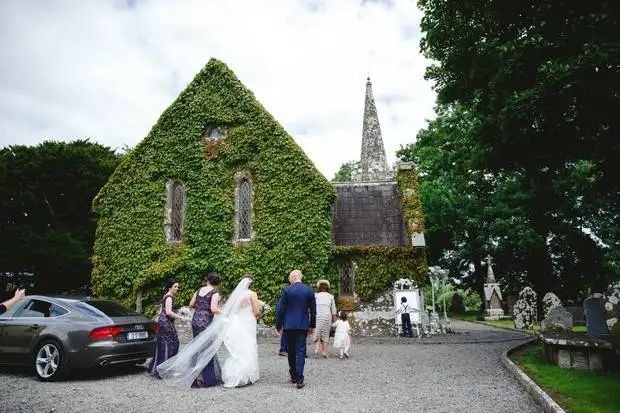 St. John's Church, Knockainey, a deconsecrated 19th-century wedding venue in County Limerick, as a bride and groom cross the gravel forecourt.
