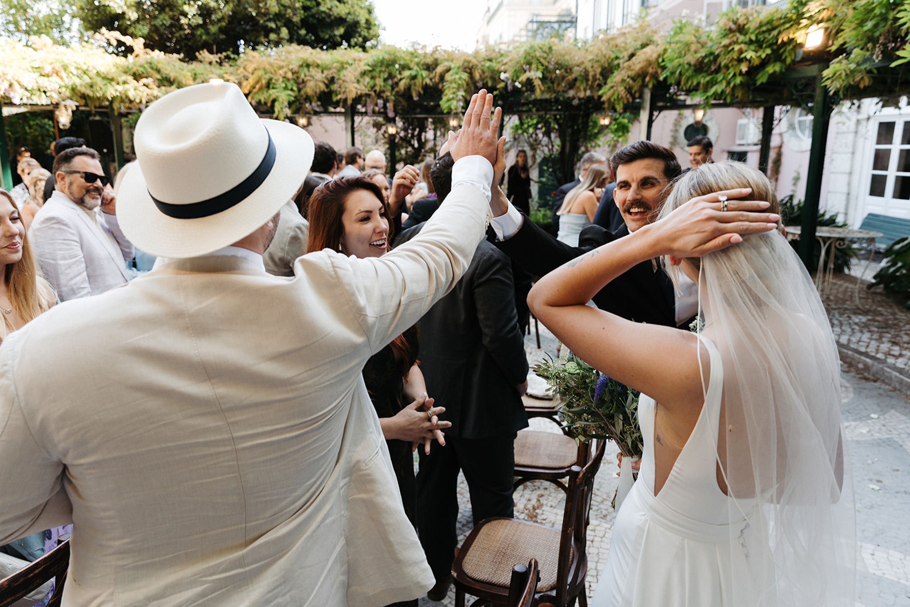 Guests celebrating and high-fiving after a joyful small wedding in Portugal reception gathering