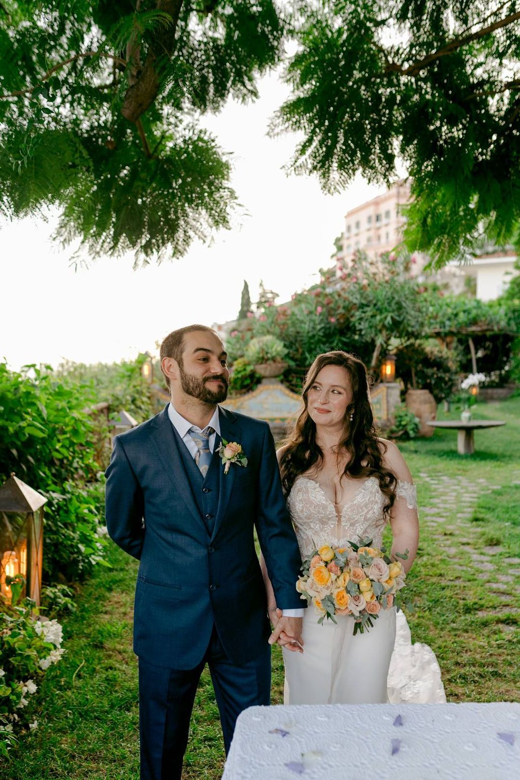 Bride looking at her groom and smiling during their Italian elopement ceremony in a terraced garden of an Amalfi Coast hotel