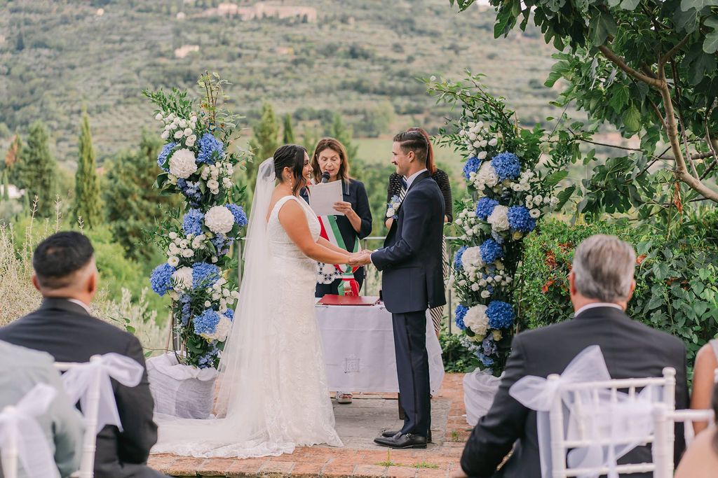 Outdoor wedding ceremony in Tuscany with bride and groom before guests at Italian countryside venue