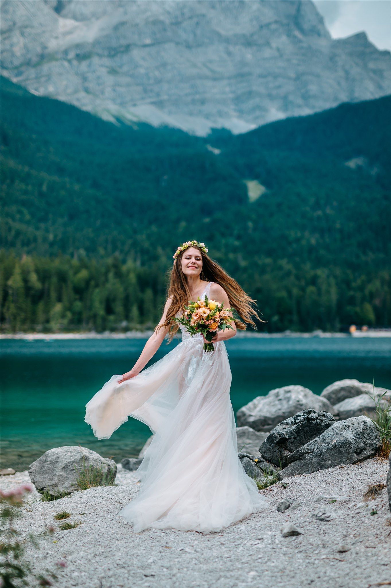 A bride enjoying the natural light while taking her portrait beside the lake during her small wedding in Germany