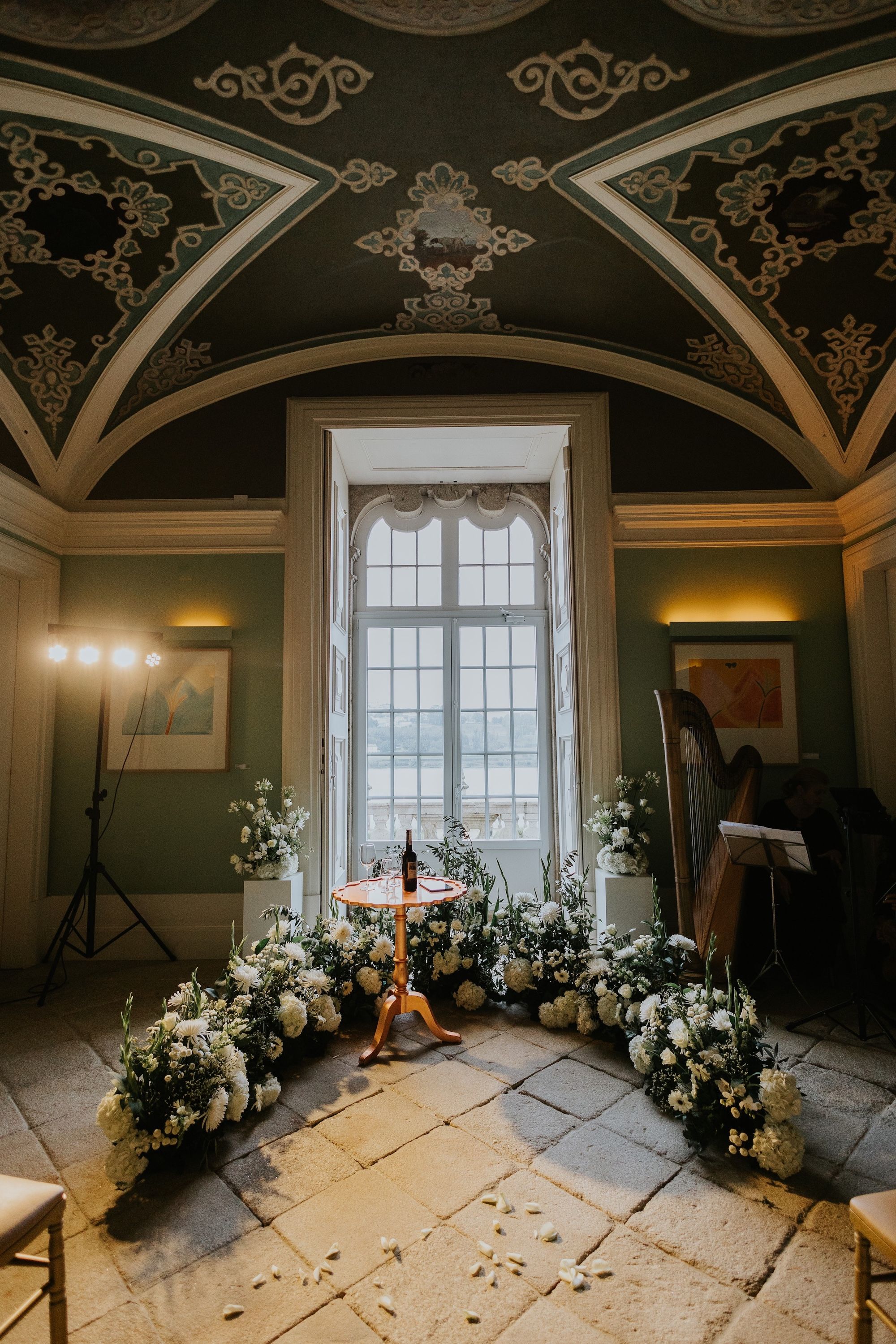 Indoor ceremony space decorated with fresh garden plants with green and white shades for a small wedding in Portugal
