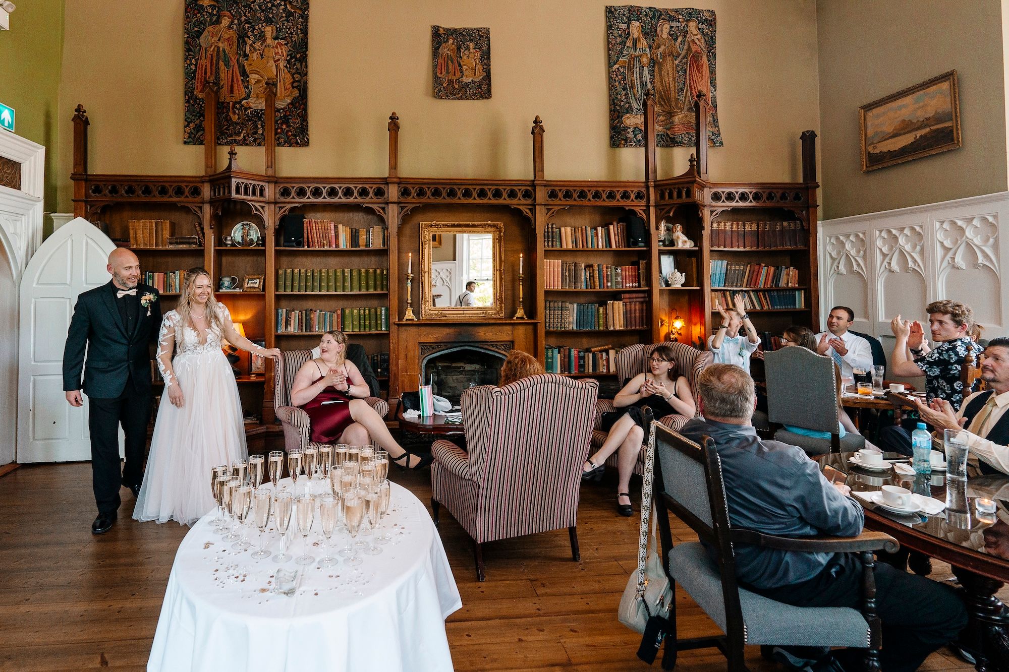 Newlyweds having drinks reception with their small group of guests in a castle library during their small wedding in Ireland