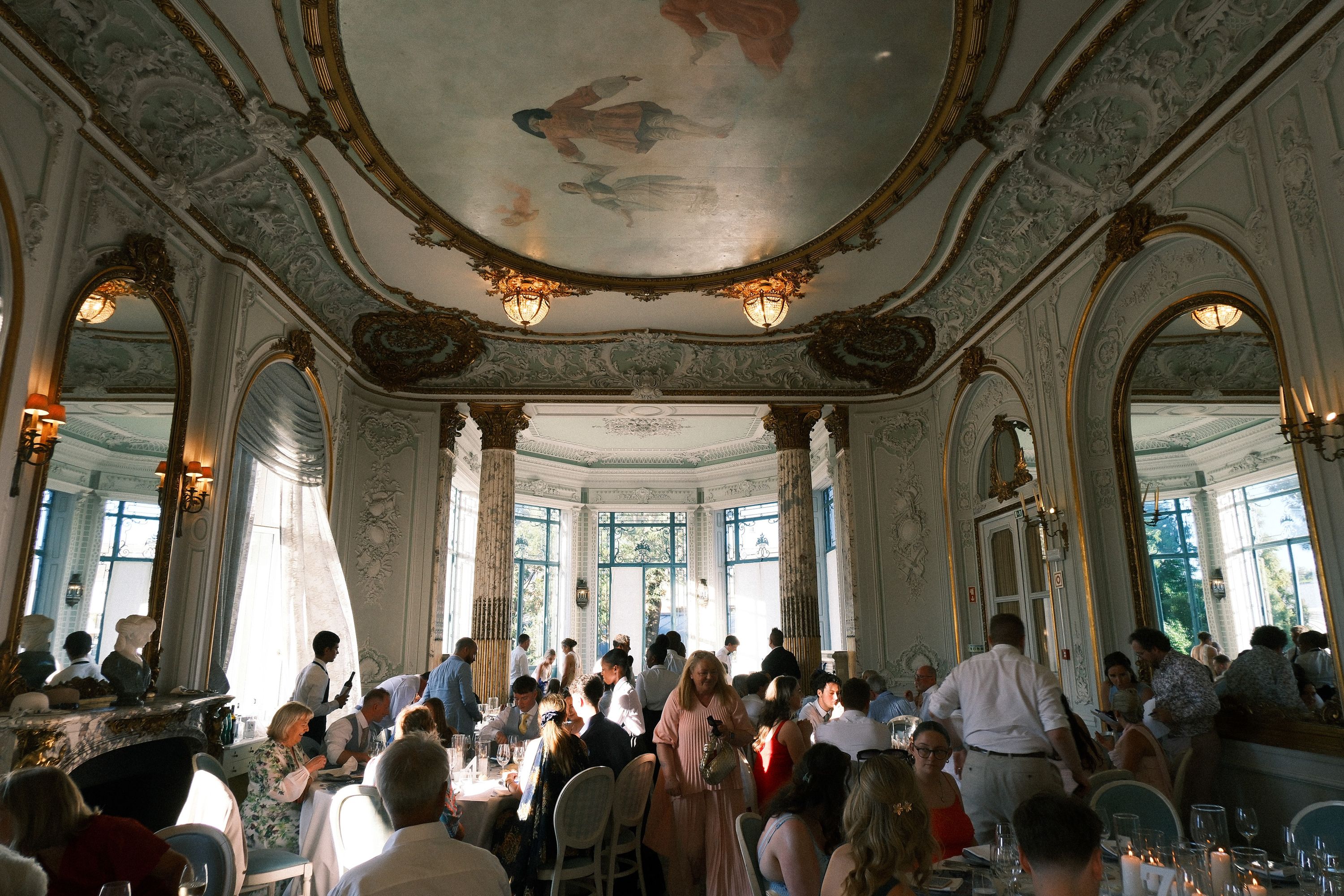 Wedding guests enjoy a reception in an ornate ballroom after a small wedding in Portugal