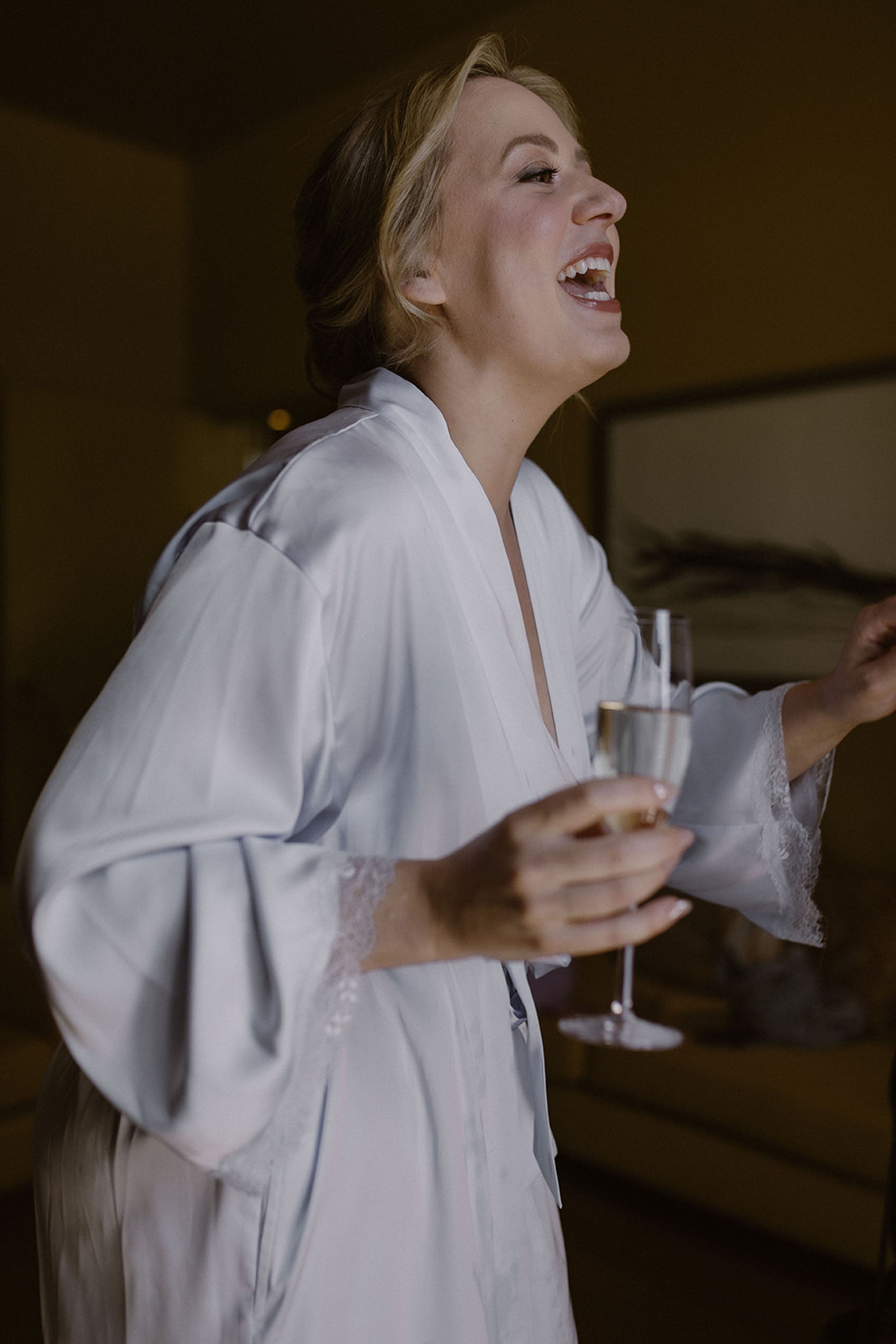 Bride laughing while getting ready with champagne before an intimate wedding in Portugal