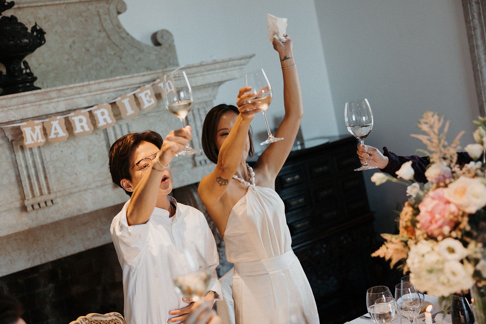 Newlyweds standing and raising their glasses for a toast during the reception of their destination wedding in Portugal