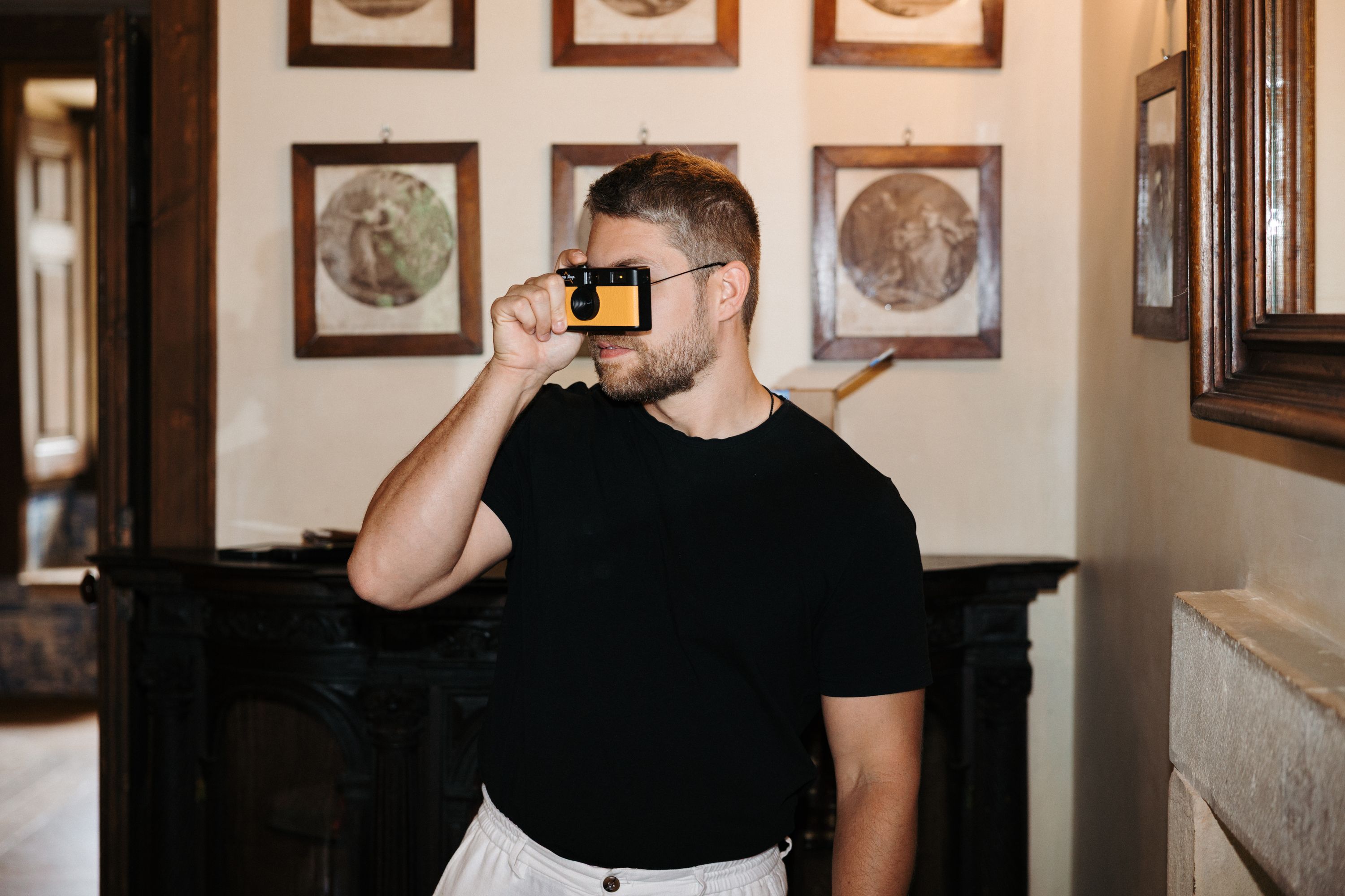 Groom taking a photograph with a disposable camera before his wedding in Portugal