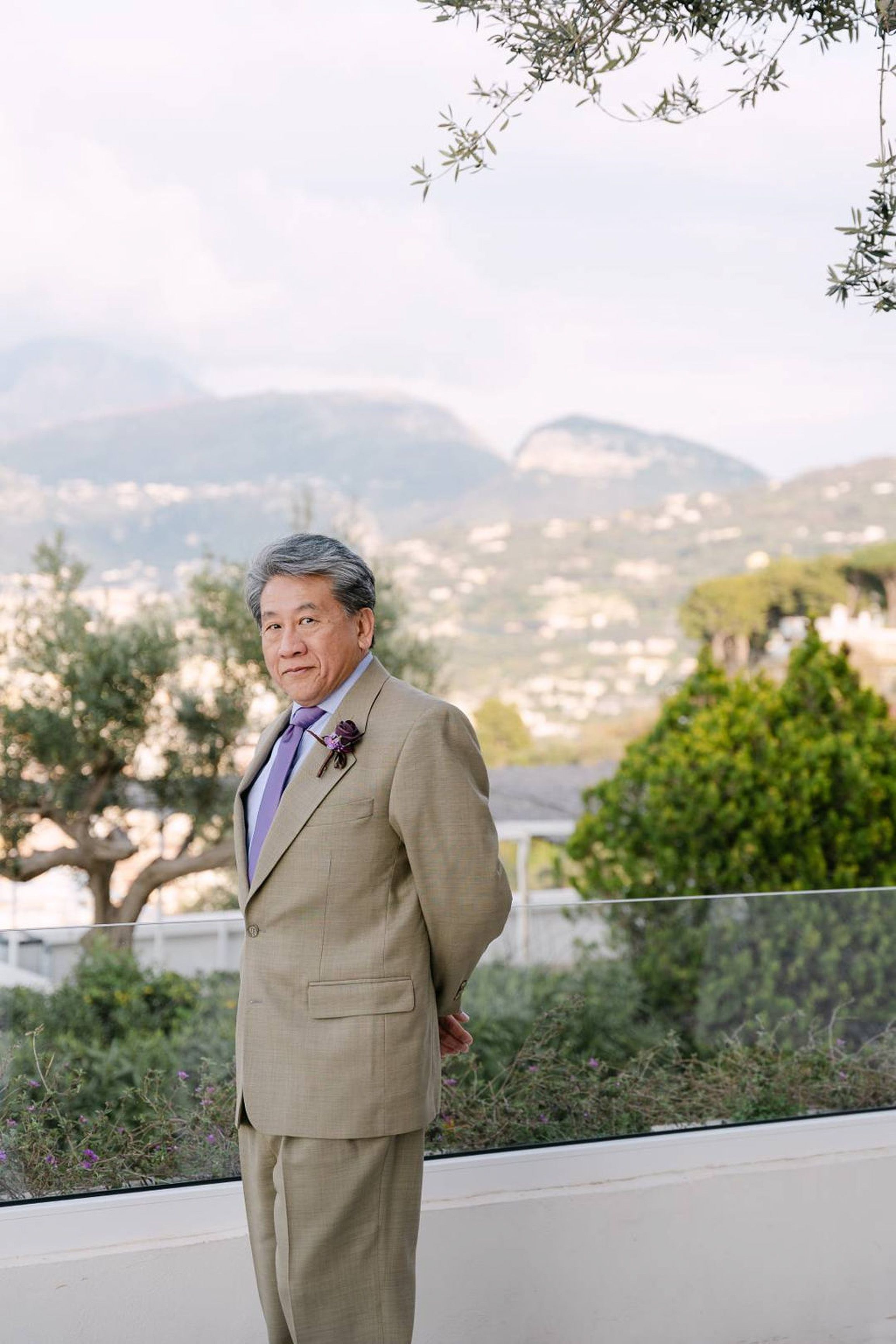 Groom portrait outdoors with mountain views and boutonniere at a small wedding in Italy