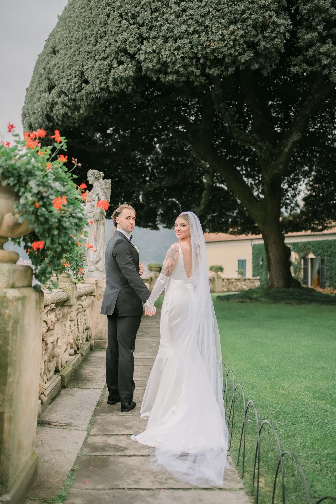 A bride and groom standing within a beautiful lakeside garden during their intimate wedding in Italy