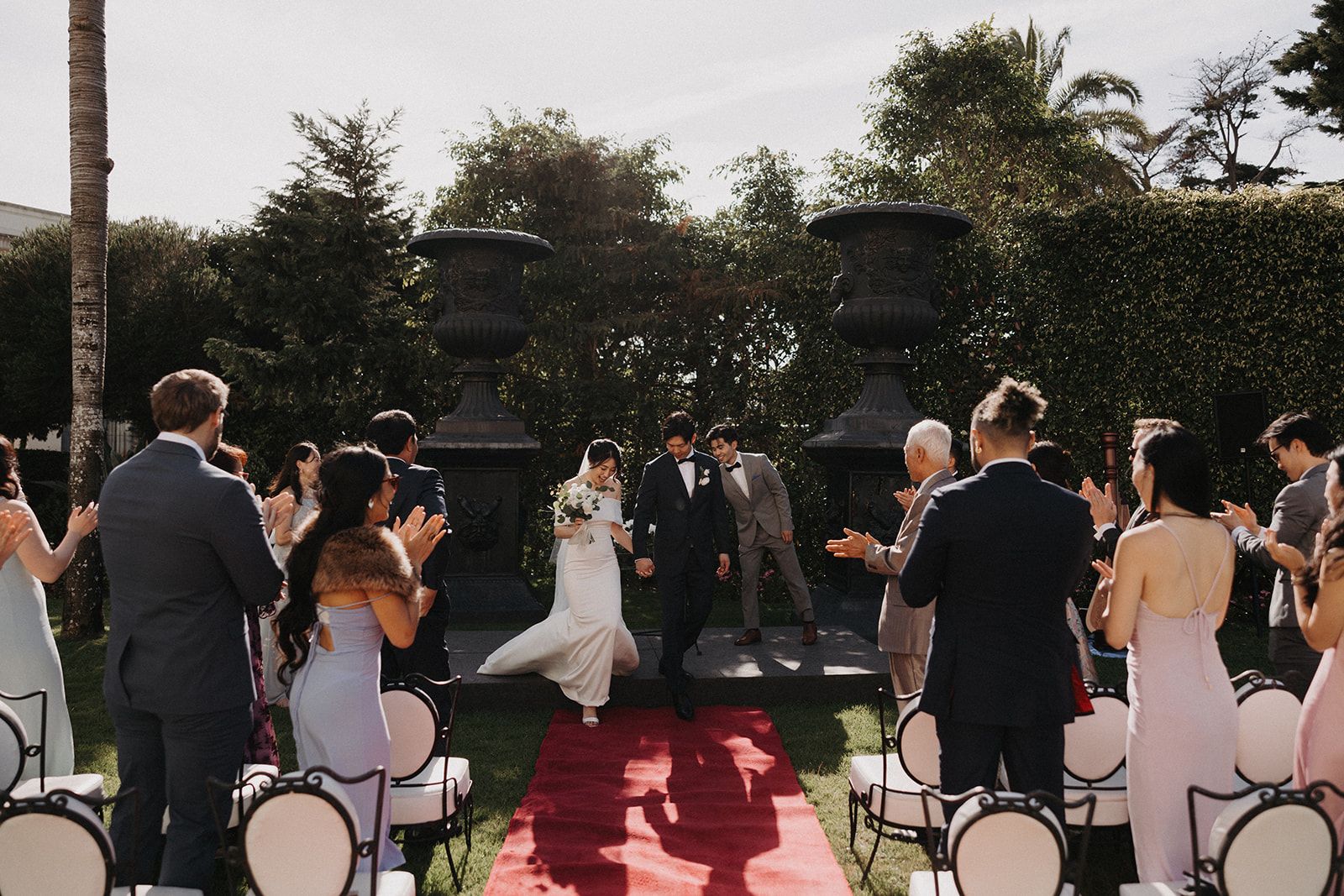 Newlyweds holding hands in front of the guests in an outdoor wedding in Portugal