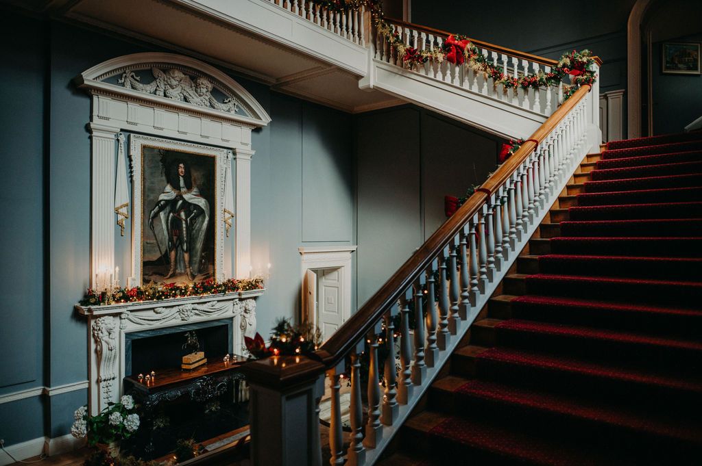 Interior staircase of an Irish castle decorated along the rails for a Christmas wedding
