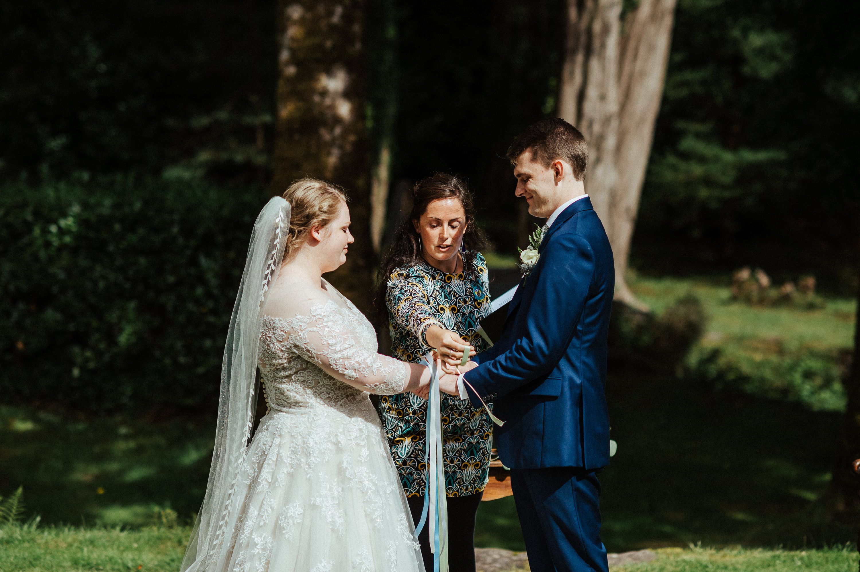 Couple taking part in a handfasting ceremony during an intimate wedding in Europe