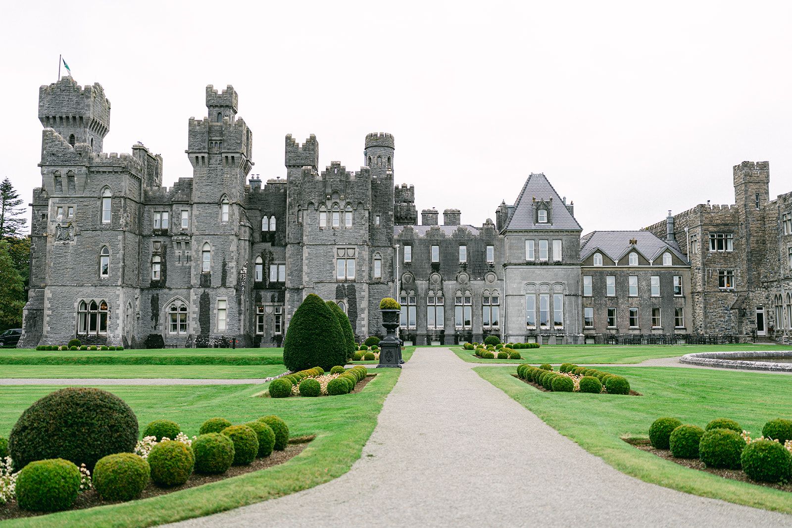 Ashford castle's facade with a beautiful formal garden for a destination wedding in Ireland