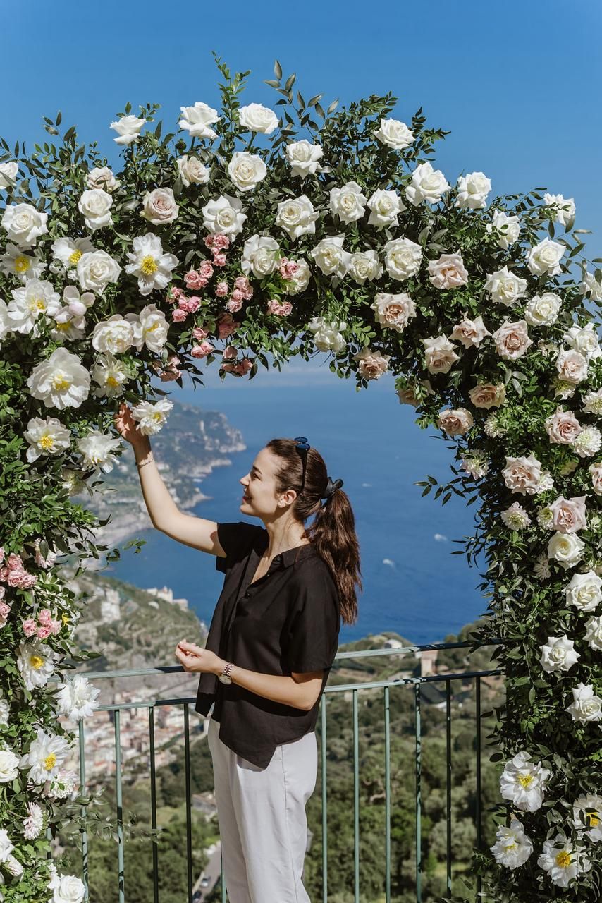 Our Italian wedding planner fixing a floral arch for a destination wedding in Amalfi