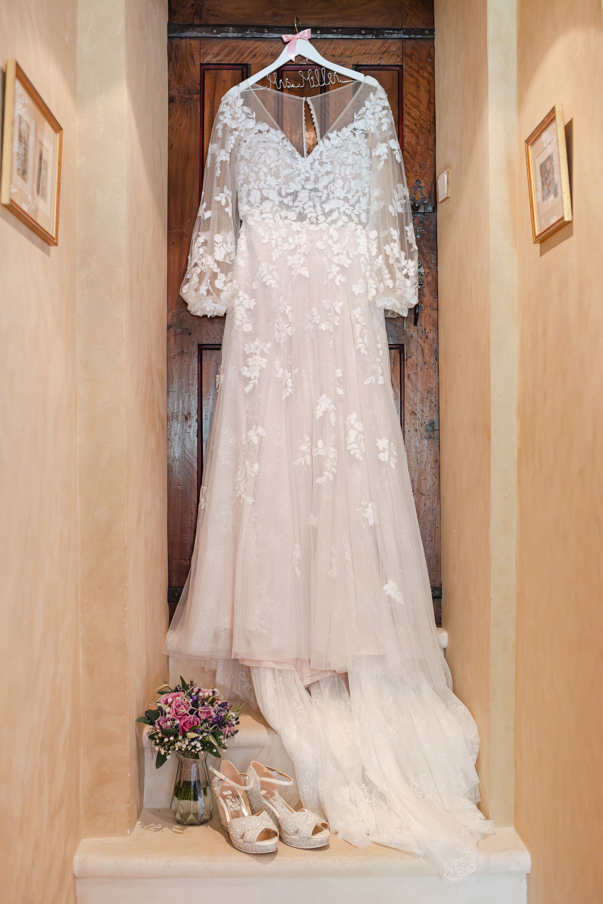 Lace wedding dress, bouquet and bridal shoes displayed before a small wedding in France