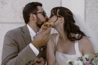 A bride and a groom in summer eating pastéis de nata