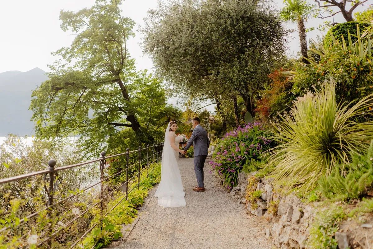 Couple walking in the garden by the Lake Como during their Italian wedding abroad in spring