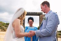 Bride and groom holding hand in front of a cerebrant as thir destination wedding in Spain